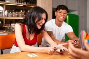 2 people laughing over card game